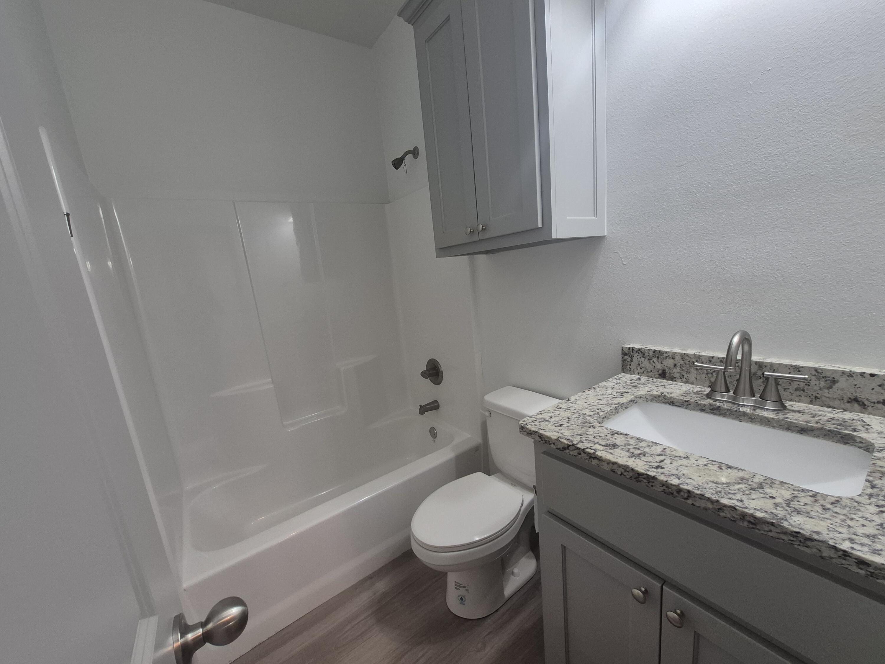 4718 125th Street Lubbock, TX 79424 - Photo 10 of 18 a bathroom with a granite countertop sink toilet and shower