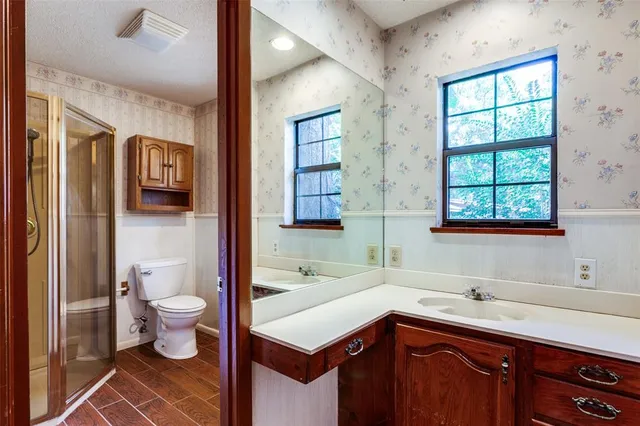 a bathroom with a toilet sink a shower and a window