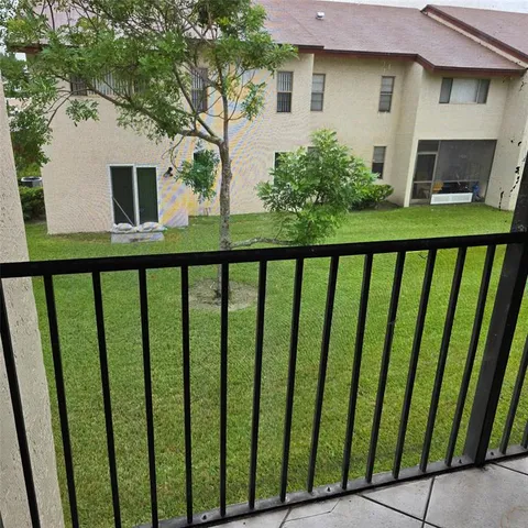a view of a house with backyard from a balcony