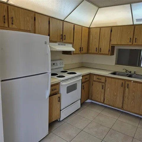 a kitchen with cabinets and white appliances