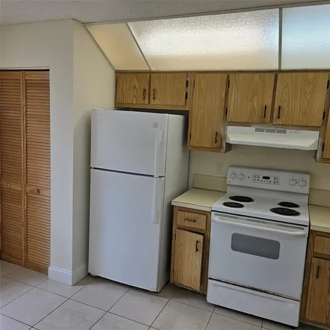 a kitchen with a stove top oven and refrigerator