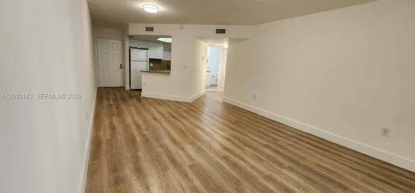a view of a livingroom with wooden floor and a large window