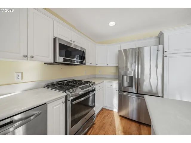 a kitchen with granite countertop a refrigerator stove and microwave