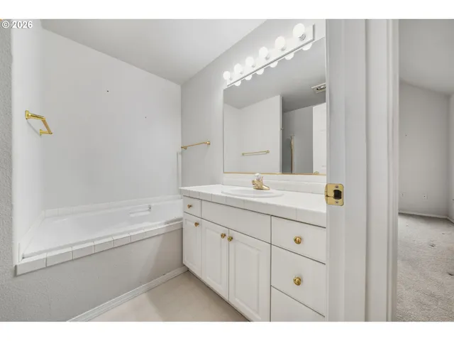 a bathroom with a double vanity sink a mirror and a bathtub