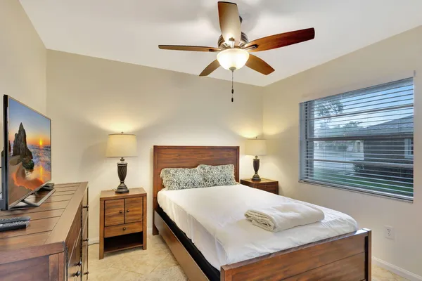 a bedroom with a bed and a flat tv screen on dresser