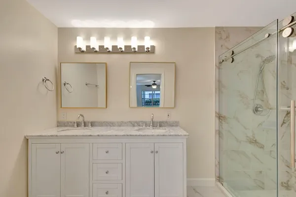 a bathroom with double sink and a mirror