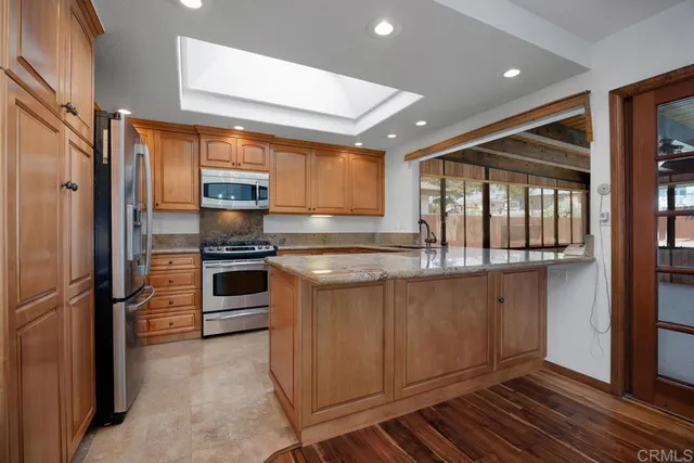 a kitchen with stainless steel appliances granite countertop a refrigerator and a sink