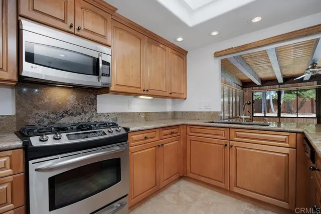 a kitchen with stainless steel appliances granite countertop a stove and a microwave
