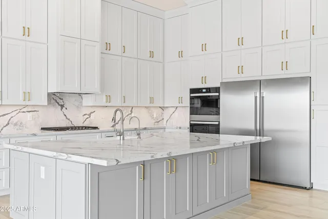 a kitchen with stainless steel appliances granite countertop a stove and a refrigerator