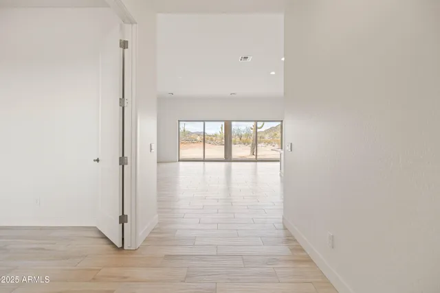 an empty room with wooden floor & windows