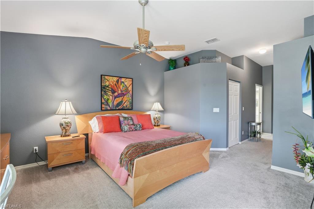 10871 Crooked River Road, Unit 202 Estero, FL 34135 - Photo 22 of 46 a bedroom with a bed and a chandelier