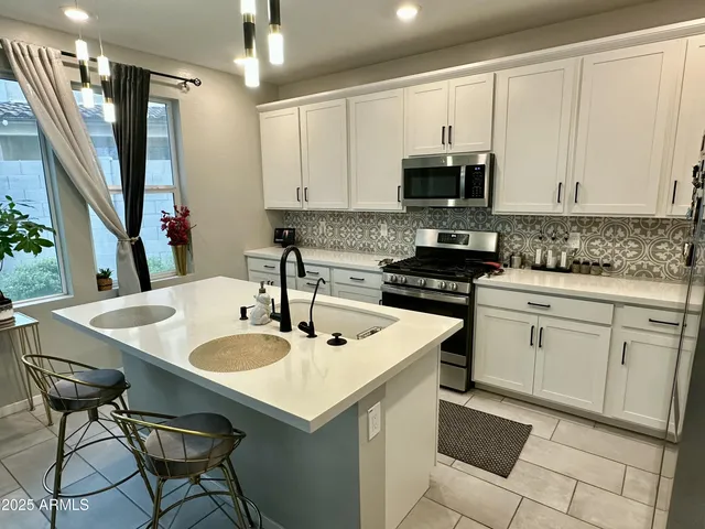 a kitchen with stainless steel appliances granite countertop a sink a microwave cabinets and a stove