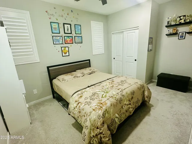 a bedroom with a bed and painting on the wall