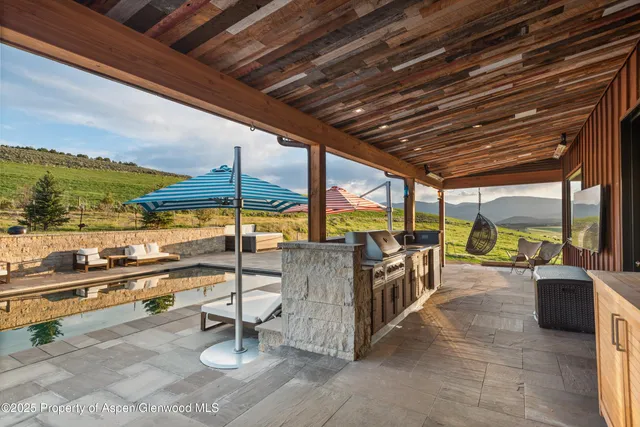 a view of a roof deck with couches and wooden floor