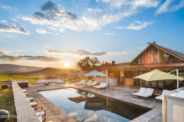 a kitchen with stainless steel appliances kitchen island granite countertop a table chairs sink and stove