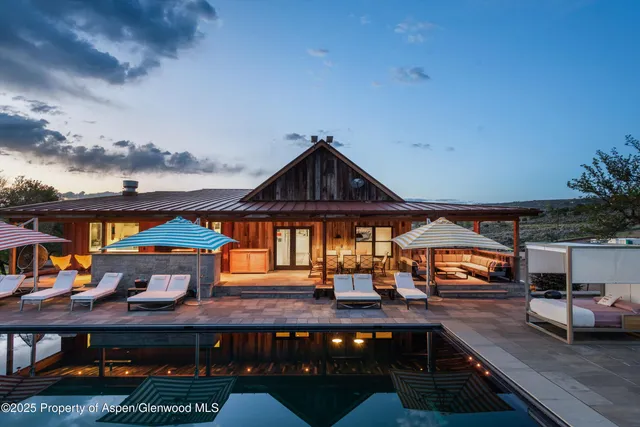 a kitchen with stainless steel appliances kitchen island granite countertop a table chairs sink and cabinets