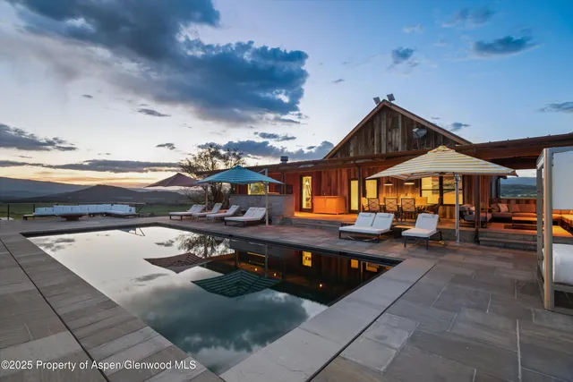 a kitchen with stainless steel appliances granite countertop a sink dishwasher a microwave oven and a dining table with wooden floor