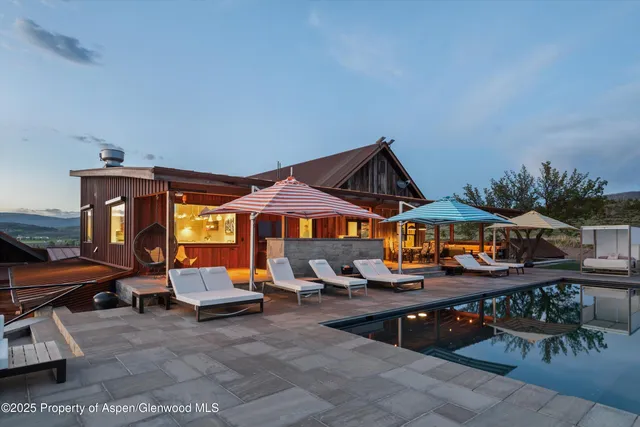 a room with stainless steel appliances kitchen island granite countertop a dining table chairs and a stove