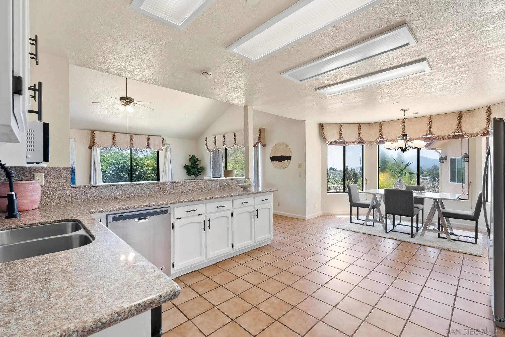 3290 Quail Way Jamul, CA 91935 - Photo 25 of 73 a kitchen with granite countertop a sink and white cabinets