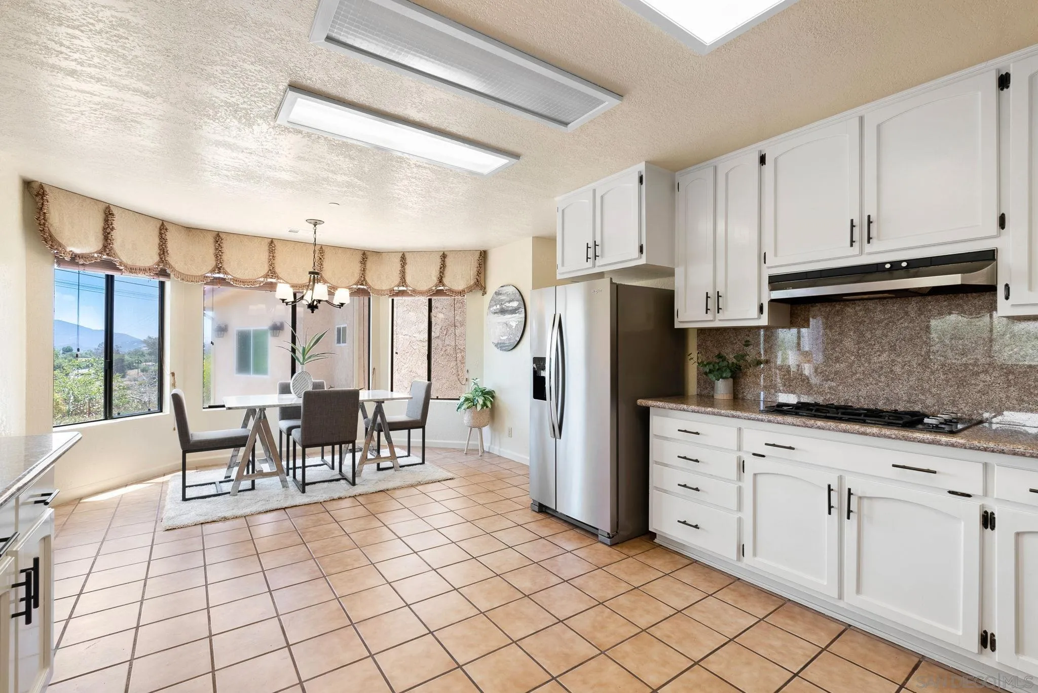 3290 Quail Way Jamul, CA 91935 - Photo 28 of 73 a kitchen with stainless steel appliances kitchen island granite countertop a refrigerator and cabinets