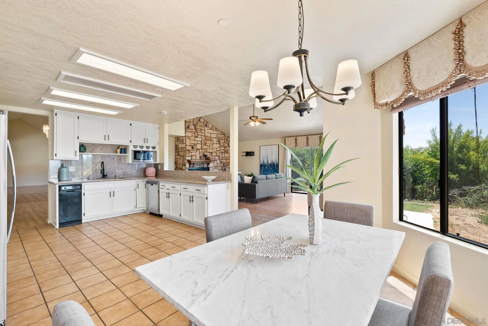 3290 Quail Way Jamul, CA 91935 - Photo 30 of 73 a kitchen with stainless steel appliances granite countertop a sink a counter top space cabinets a dining table and chairs