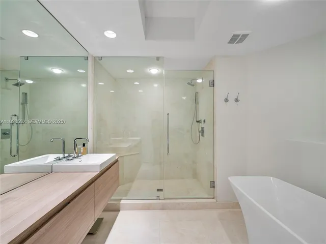 a bathroom with a double vanity sink mirror and shower