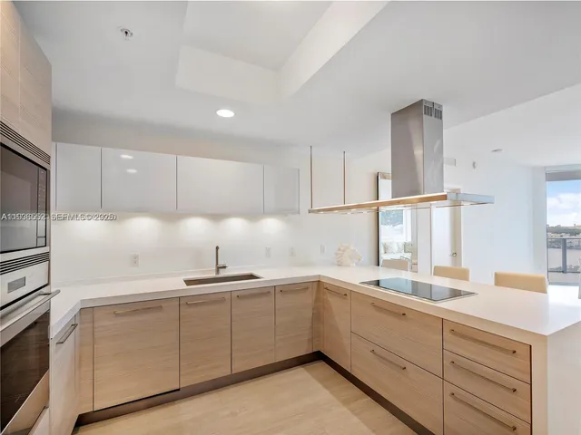 a kitchen with a sink a stove top oven and kitchen island