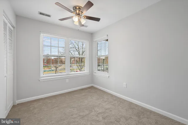an empty room with a window and a fan
