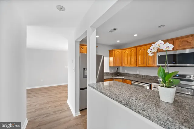 a kitchen with stainless steel appliances granite countertop a refrigerator a sink a stove and dishwasher