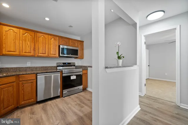 a kitchen with stainless steel appliances granite countertop a stove a sink and a refrigerator