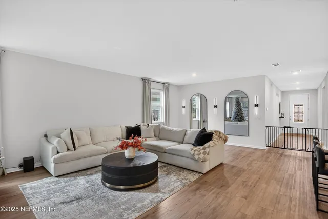 a living room with furniture and a wooden floor