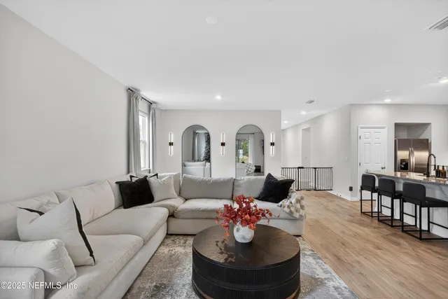 a living room with furniture and a dining table with wooden floor