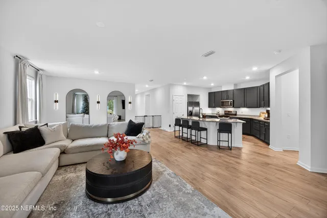 a living room with furniture kitchen and a table