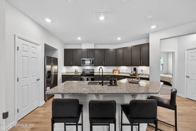 a large kitchen with granite countertop lots of counter space and dining table