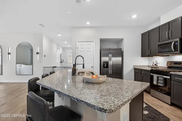 a kitchen with granite countertop a sink and stainless steel appliances