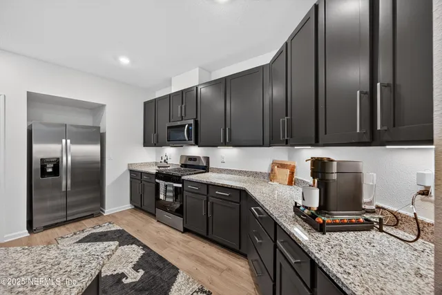 a kitchen with stainless steel appliances granite countertop a sink stove and refrigerator