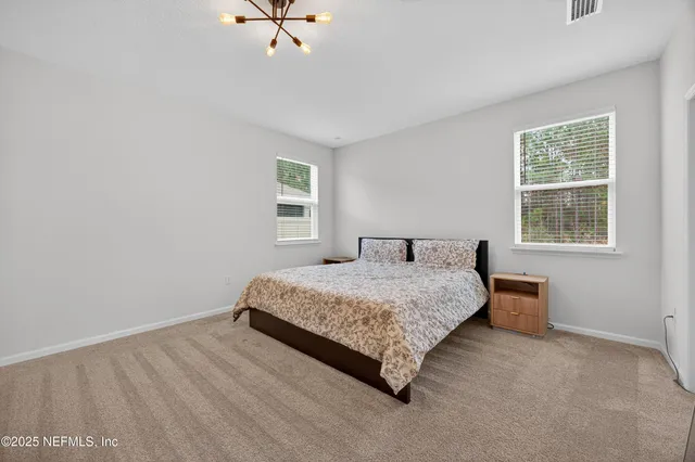 a spacious bedroom with a bed and a window