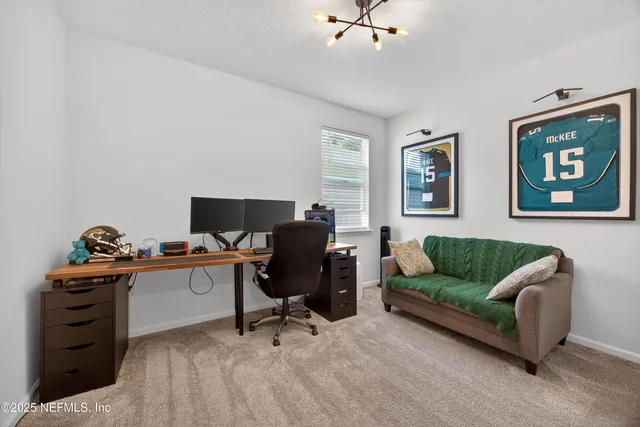 a livingroom with workspace and a couch