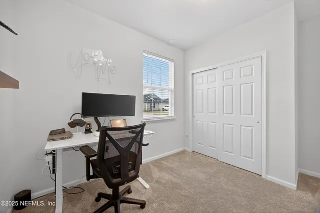 a view of a workspace with furniture and a window