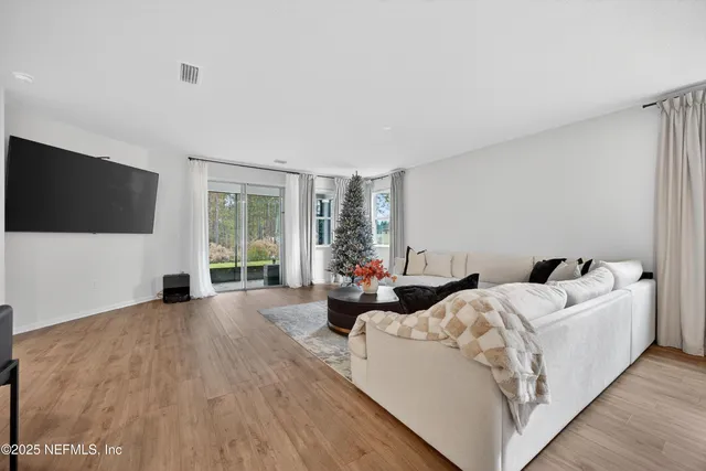 a living room with furniture a flat screen tv and a large window