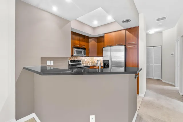 a kitchen with granite countertop a sink and refrigerator