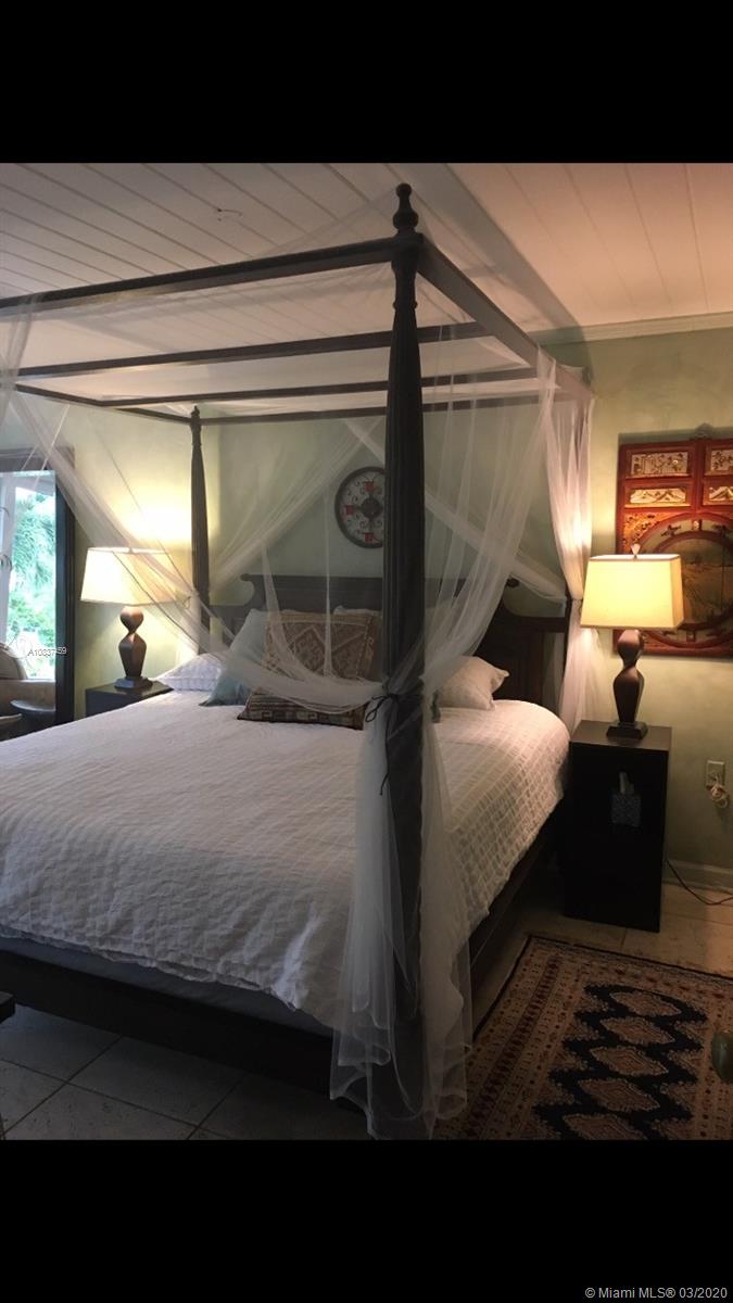 7975 Biscayne Point Circle Miami Beach, FL 33141 - Photo 26 of 34 a bedroom with a bed and a mirror