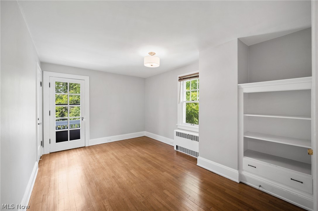 2924 Brighton Road Shaker Heights, OH 44120 - Photo 19 of 31 Empty room featuring radiator, baseboards, wood-type flooring, and plenty of natural light