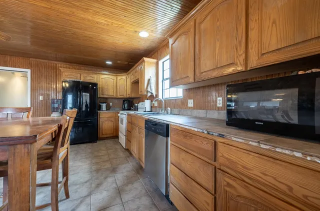 a kitchen with a stove a table and chairs in it