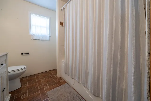 a living room with furniture a ceiling fan and a rug