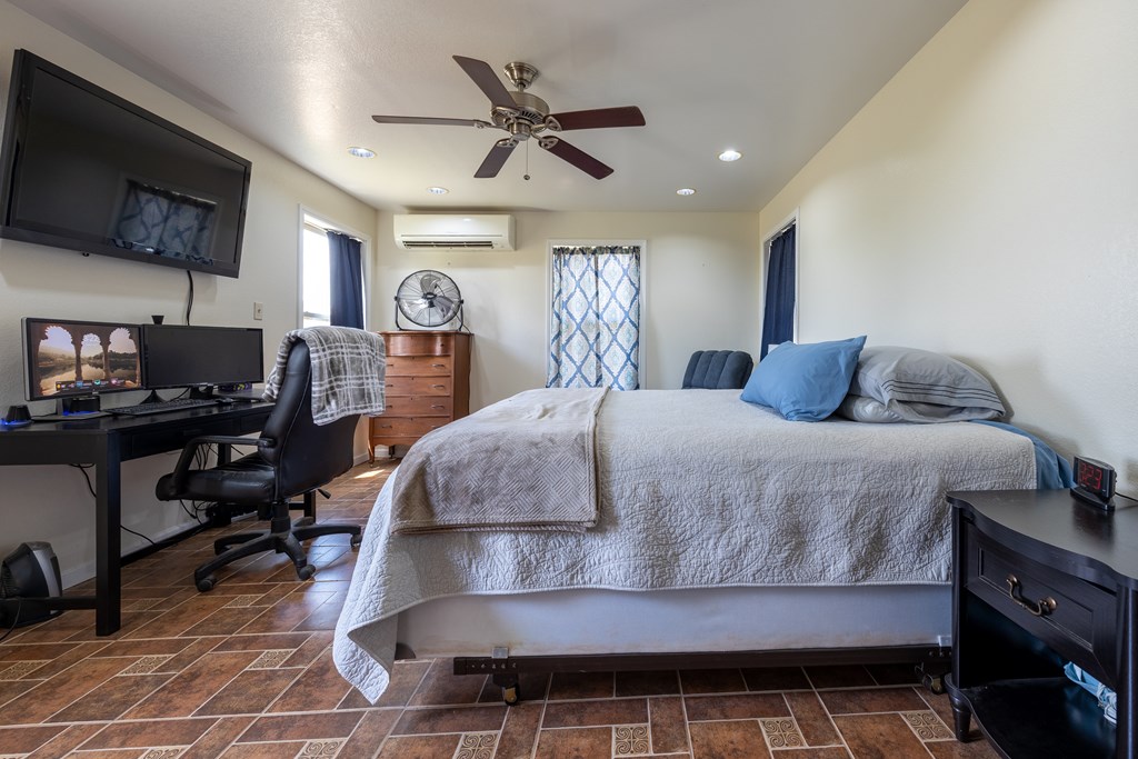 1596 Mule Creek Road Robert Lee, TX 76945 - Photo 14 of 98 a bedroom with a bed a flat screen tv and a dresser