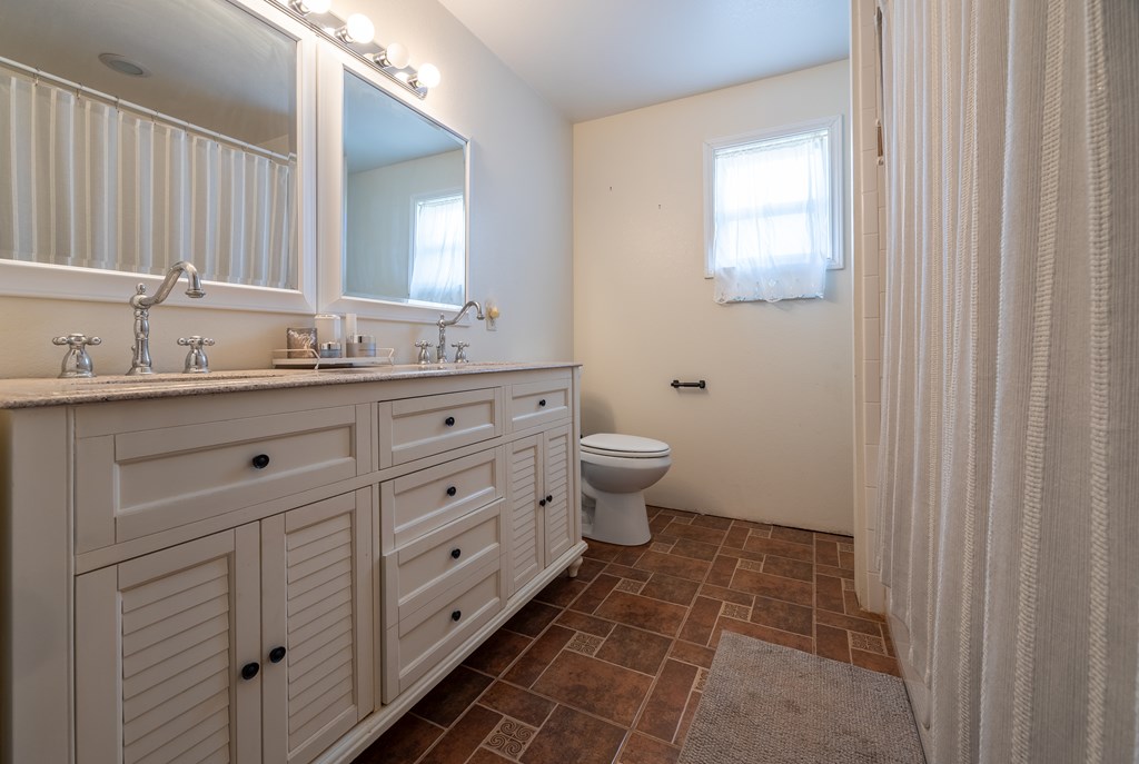 1596 Mule Creek Road Robert Lee, TX 76945 - Photo 26 of 98 a spacious bathroom with a double vanity sink a toilet and a mirror