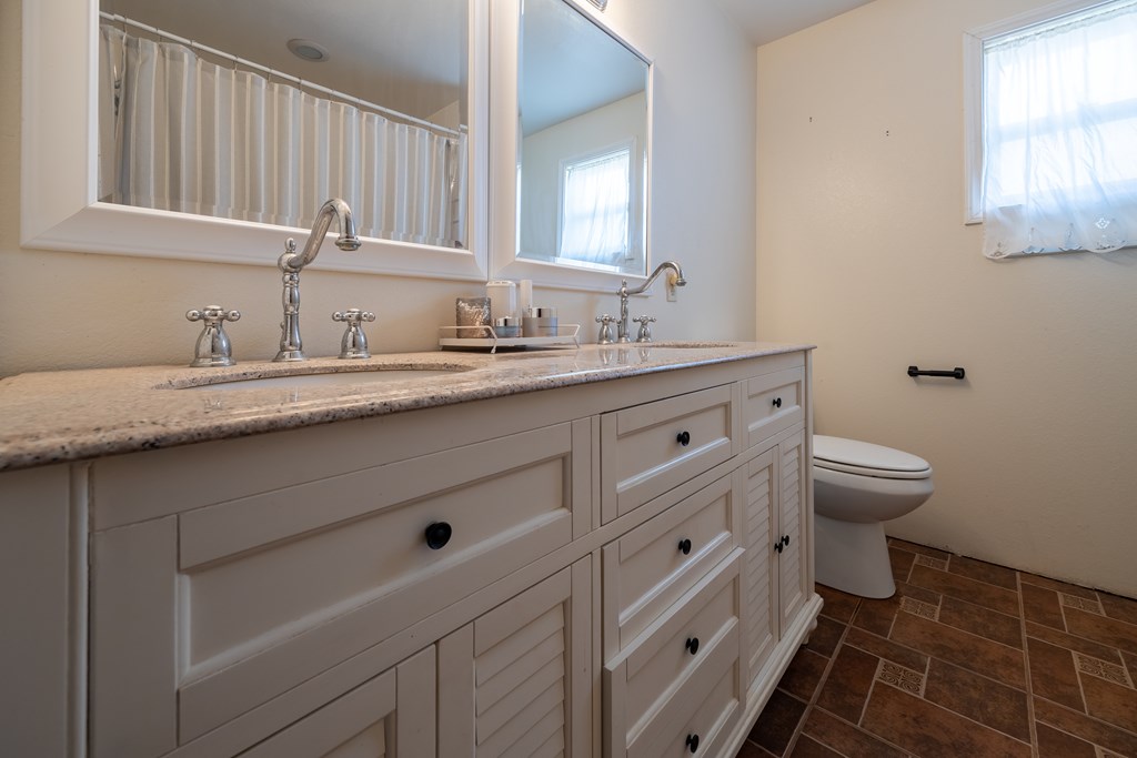 1596 Mule Creek Road Robert Lee, TX 76945 - Photo 33 of 98 a bathroom with a granite countertop toilet sink and mirror