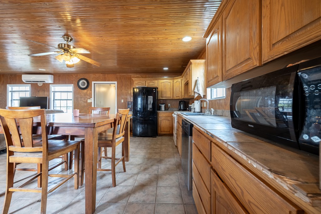 1596 Mule Creek Road Robert Lee, TX 76945 - Photo 36 of 98 a kitchen with stainless steel appliances kitchen island granite countertop a stove a sink a dining table and chairs