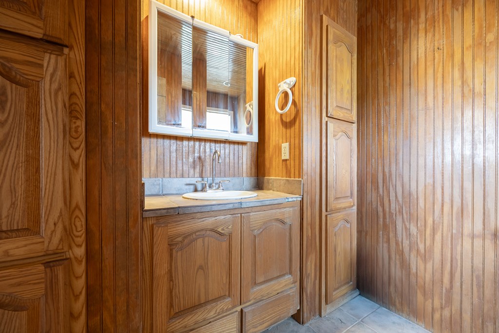 1596 Mule Creek Road Robert Lee, TX 76945 - Photo 38 of 98 a bathroom with a granite countertop sink and a mirror